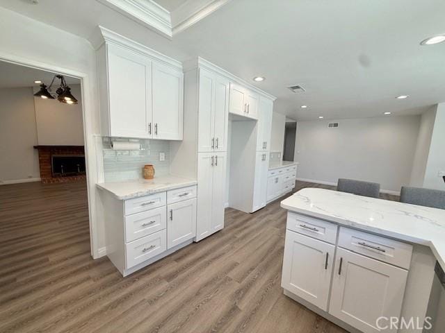 16413 Abascal Dr, Hacienda Heights, CA 91745 - kitchen with white cabinetry, light wood-type flooring, backsplash, recessed lighting, and light stone countertops