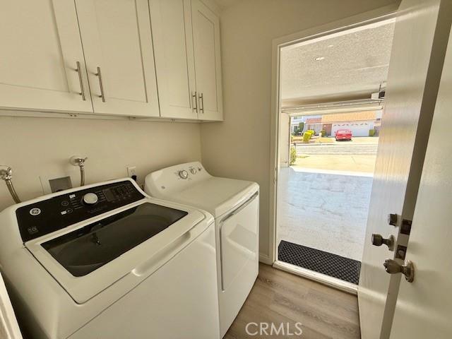 16413 Abascal Dr, Hacienda Heights, CA 91745 - laundry area featuring washer and clothes dryer, cabinet space, and light wood-type flooring