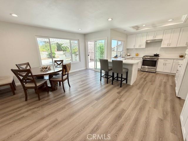 16413 Abascal Dr, Hacienda Heights, CA 91745 - kitchen with stainless steel range, recessed lighting, light countertops, white cabinets, and light wood-style flooring