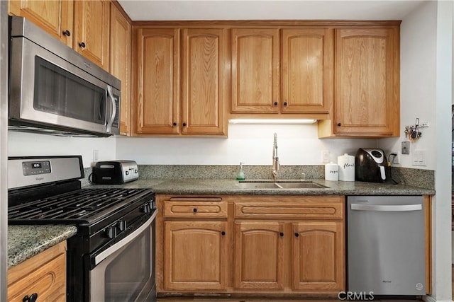 27074 Hidaway Ave Unit 3, Canyon Country, CA 91351 - kitchen featuring stainless steel appliances, brown cabinets, and dark stone counters