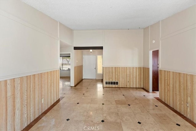 1897 Taylor Ave, Corona, CA 92882 - unfurnished room with a wainscoted wall, wooden walls, a textured ceiling, and light tile patterned floors