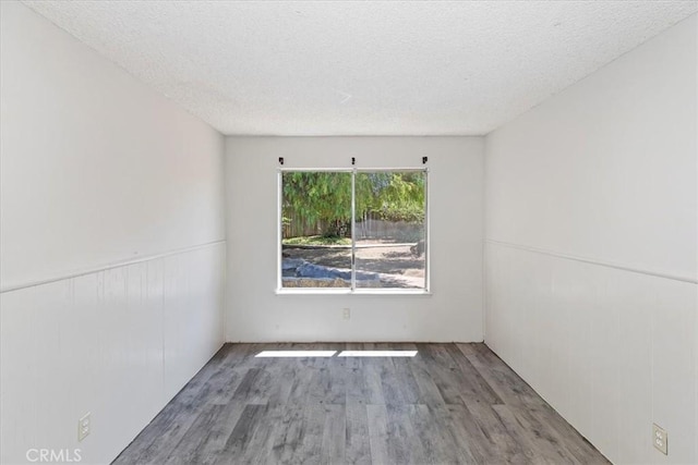 1897 Taylor Ave, Corona, CA 92882 - spare room featuring wood finished floors, a textured ceiling, and a wainscoted wall