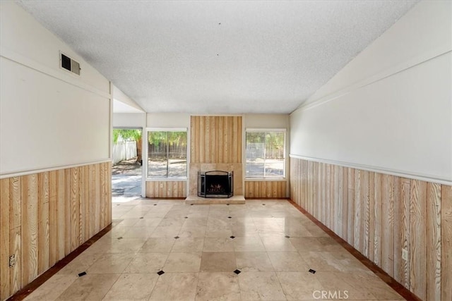 1897 Taylor Ave, Corona, CA 92882 - unfurnished living room featuring healthy amount of natural light, a wainscoted wall, wooden walls, a textured ceiling, and heating unit
