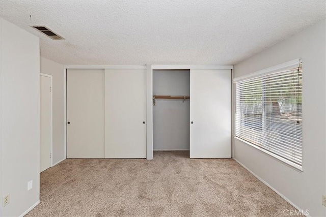 1897 Taylor Ave, Corona, CA 92882 - unfurnished bedroom featuring two closets, carpet, and a textured ceiling
