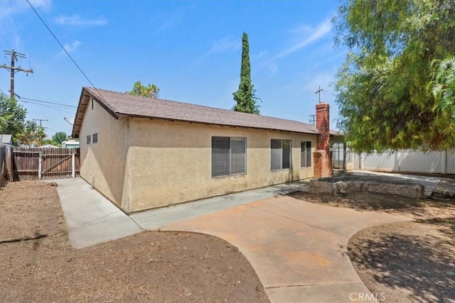 1897 Taylor Ave, Corona, CA 92882 - back of property with stucco siding, a chimney, and a patio