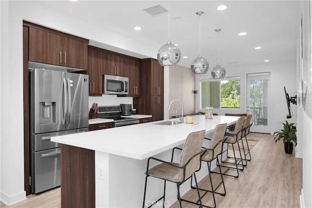 9958 Artesia Blvd Unit 1003, Bellflower, CA 90706 - kitchen with stainless steel appliances, a spacious island, light countertops, a kitchen bar, and recessed lighting
