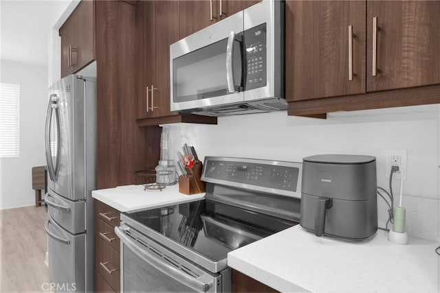 9958 Artesia Blvd Unit 1003, Bellflower, CA 90706 - kitchen with appliances with stainless steel finishes, light countertops, and dark brown cabinets