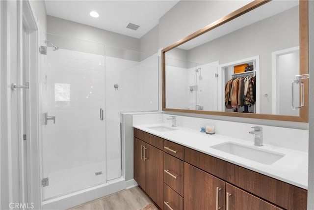 9958 Artesia Blvd Unit 1003, Bellflower, CA 90706 - bathroom with a stall shower, double vanity, a spacious closet, and wood finished floors