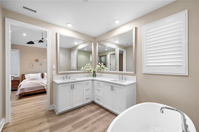 103 Winnett, Irvine, CA 92602 - bathroom with double vanity, a freestanding tub, wood finished floors, ensuite bath, and recessed lighting