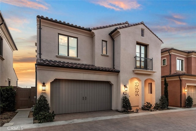 103 Winnett, Irvine, CA 92602 - mediterranean / spanish-style house featuring a balcony, a tiled roof, a garage, and stucco siding