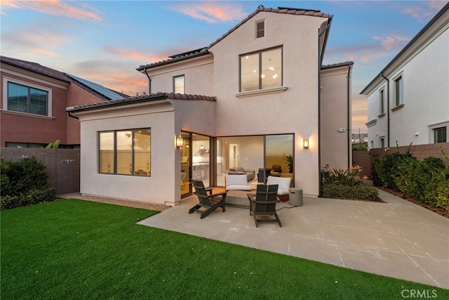 103 Winnett, Irvine, CA 92602 - back of house at dusk with a patio area, a fenced backyard, a tiled roof, and stucco siding