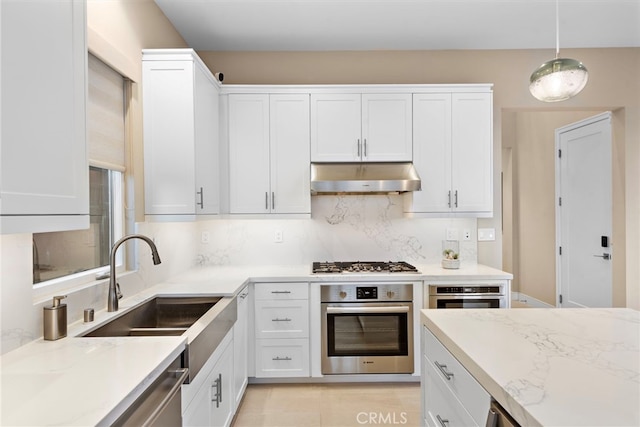 103 Winnett, Irvine, CA 92602 - kitchen with stainless steel appliances, under cabinet range hood, white cabinets, decorative backsplash, and light stone counters