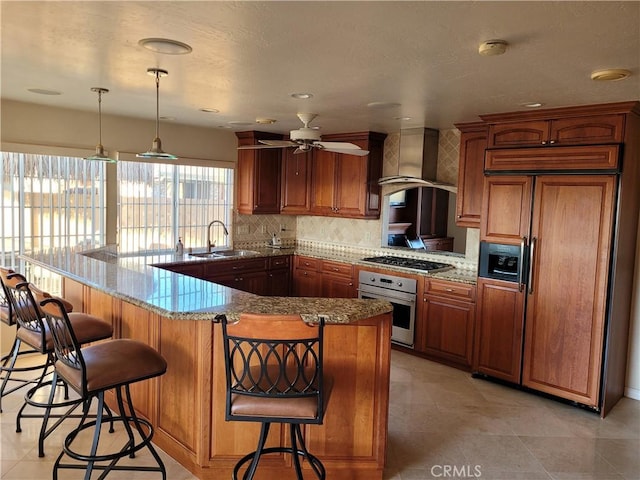 10840 New Salem Pt, San Diego, CA 92126 - kitchen featuring stainless steel appliances, wall chimney range hood, ceiling fan, backsplash, and brown cabinetry
