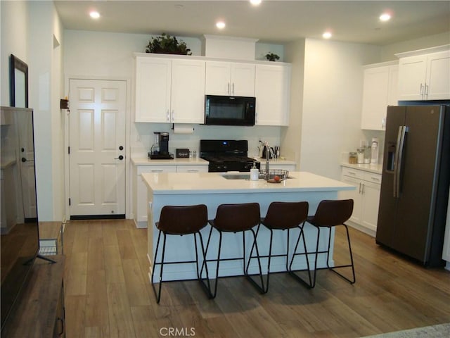 435 N Beechwood Ave, Rialto, CA 92376 - kitchen featuring stainless steel refrigerator with ice dispenser, black microwave, stove, dark wood-style flooring, and light countertops