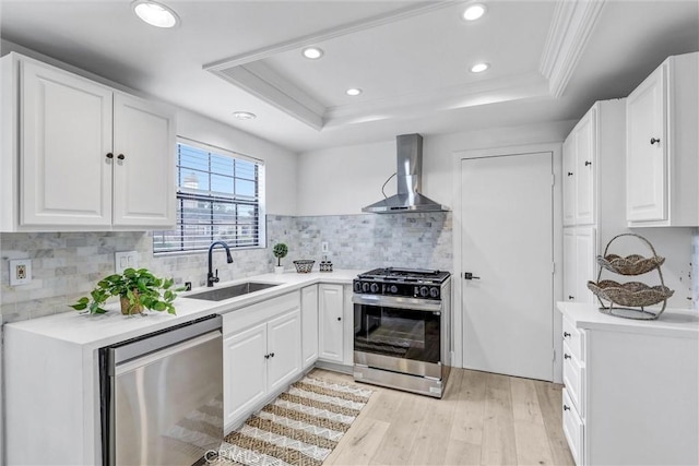 2633 Monte Carlo Dr Unit 41, Santa Ana, CA 92706 - kitchen featuring stainless steel appliances, wall chimney exhaust hood, a tray ceiling, light wood-style floors, and recessed lighting