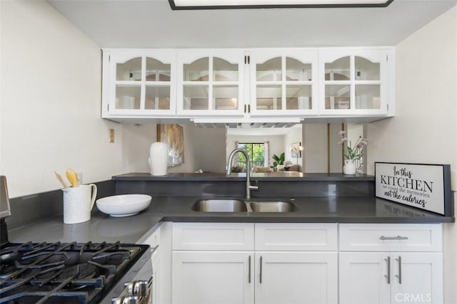 13725 Los Angeles St Unit H, Baldwin Park, CA 91706 - kitchen with stainless steel gas range, dark countertops, glass insert cabinets, and white cabinetry