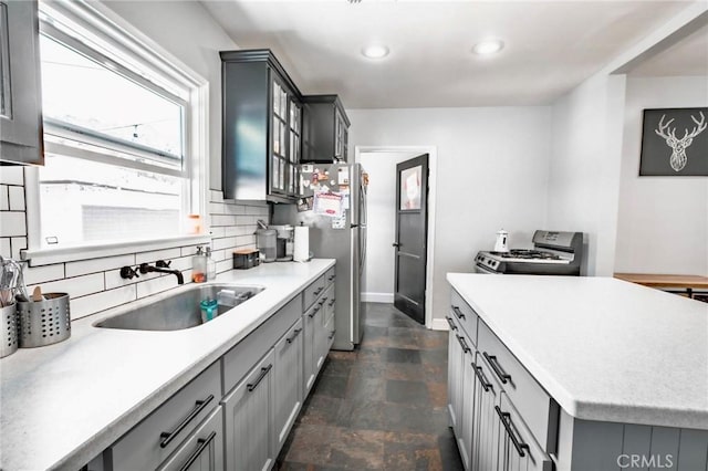 5855 Daneland St, Lakewood, CA 90713 - kitchen with white gas range oven, stone finish floors, gray cabinetry, freestanding refrigerator, and backsplash
