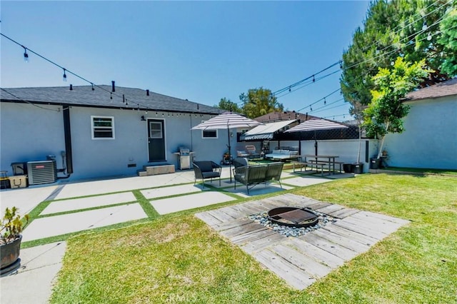 5855 Daneland St, Lakewood, CA 90713 - back of property featuring stucco siding, a patio area, a lawn, and an outdoor living space with a fire pit