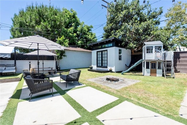 5855 Daneland St, Lakewood, CA 90713 - view of yard featuring a patio, a playground, an outdoor structure, and an outdoor living space with a fire pit
