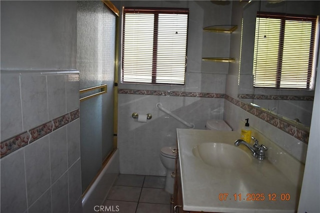 1331 Bothwell Ave, Colton, CA 92324 - bathroom featuring tile walls, vanity, tile patterned flooring, healthy amount of natural light, and combined bath / shower with glass door