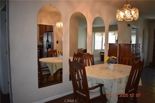 1331 Bothwell Ave, Colton, CA 92324 - dining room with a chandelier, arched walkways, and dark wood-style floors