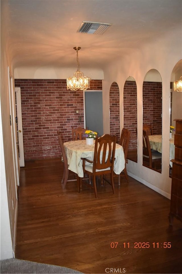 1331 Bothwell Ave, Colton, CA 92324 - dining room featuring a chandelier, brick wall, and wood finished floors
