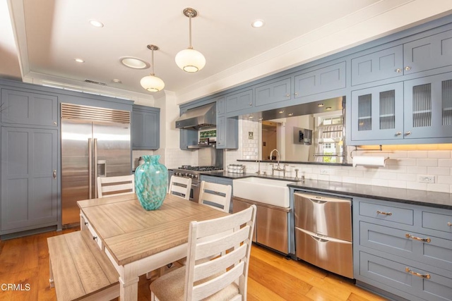 5512 Ranchito Ave, Sherman Oaks, CA 91401 - kitchen with high end appliances, extractor fan, tasteful backsplash, glass insert cabinets, and dark countertops