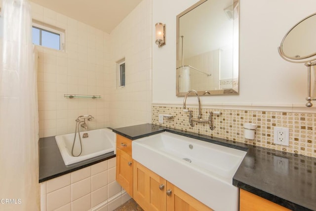 5512 Ranchito Ave, Sherman Oaks, CA 91401 - bathroom with a relaxing tiled tub, vanity, tile walls, and tasteful backsplash