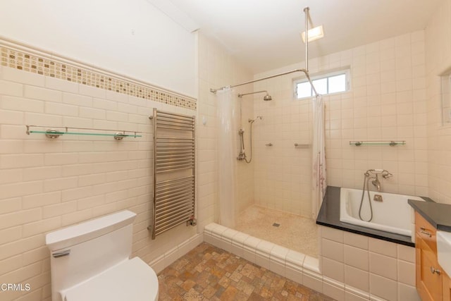 5512 Ranchito Ave, Sherman Oaks, CA 91401 - bathroom with radiator heating unit, tiled shower, tile walls, tiled bath, and vanity