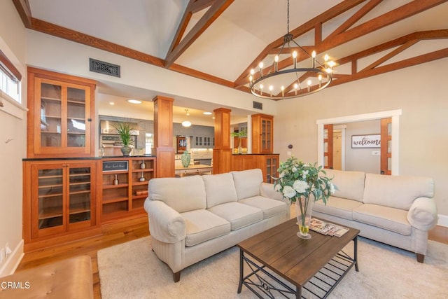 5512 Ranchito Ave, Sherman Oaks, CA 91401 - living room featuring beamed ceiling, light wood-type flooring, a chandelier, decorative columns, and high vaulted ceiling