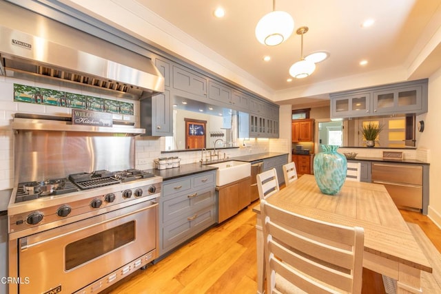 5512 Ranchito Ave, Sherman Oaks, CA 91401 - kitchen featuring gray cabinetry, appliances with stainless steel finishes, range hood, dark countertops, and backsplash