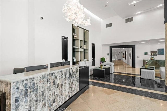 3131 Michelson Dr Unit 901, Irvine, CA 92612 - reception area featuring a high ceiling, a bar, and a chandelier
