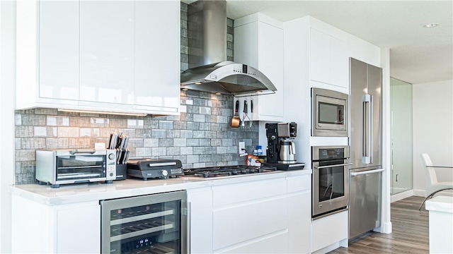 3131 Michelson Dr Unit 901, Irvine, CA 92612 - kitchen featuring wall chimney range hood, stainless steel appliances, beverage cooler, light countertops, and light wood-style floors