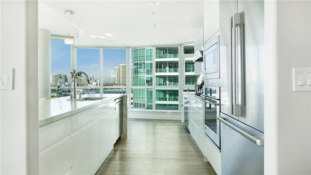 3131 Michelson Dr Unit 901, Irvine, CA 92612 - kitchen featuring modern cabinets, appliances with stainless steel finishes, white cabinets, wood finished floors, and a city view