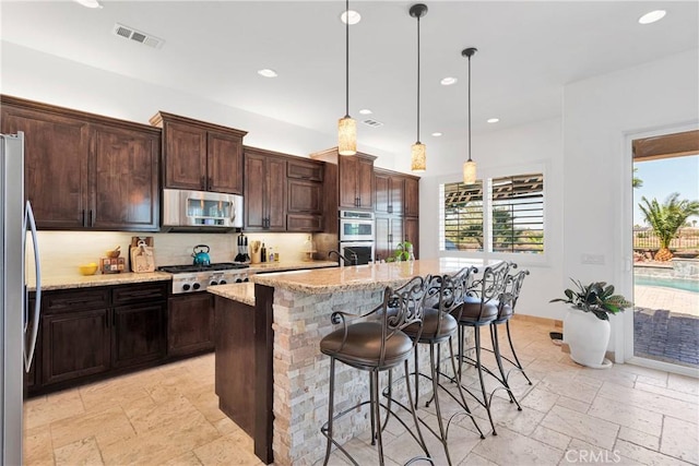 10844 Aster Ln, Apple Valley, CA 92308 - kitchen with stainless steel appliances, stone tile flooring, light stone countertops, backsplash, and recessed lighting