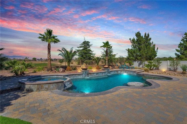 10844 Aster Ln, Apple Valley, CA 92308 - pool at dusk featuring a pool with connected hot tub, a fenced backyard, and a patio area