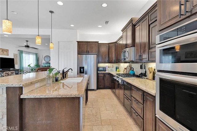 10844 Aster Ln, Apple Valley, CA 92308 - kitchen with appliances with stainless steel finishes, stone tile floors, recessed lighting, dark brown cabinets, and hanging light fixtures