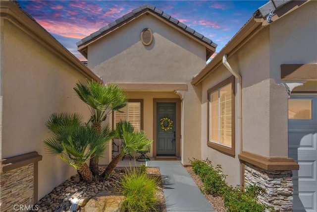 10844 Aster Ln, Apple Valley, CA 92308 - exterior entry at dusk featuring stucco siding and a garage
