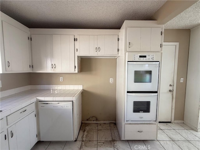 2854 Coronado Ave, San Diego, CA 92154 - kitchen featuring white appliances, tile counters, a textured ceiling, and white cabinetry