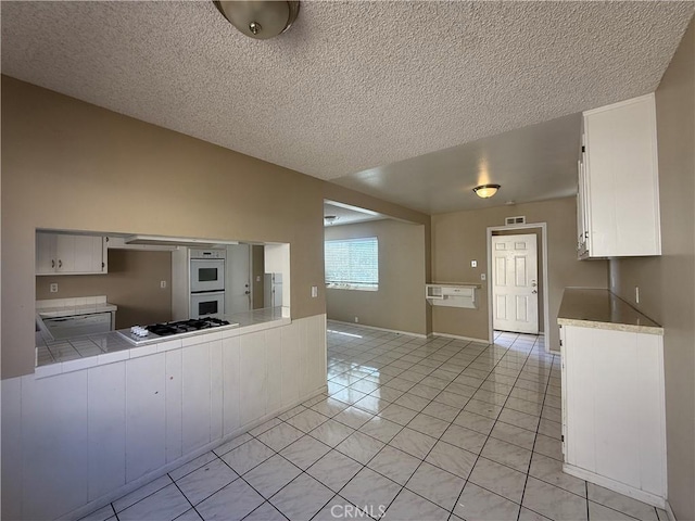 2854 Coronado Ave, San Diego, CA 92154 - kitchen featuring white appliances, light tile patterned floors, white cabinets, tile counters, and a textured ceiling