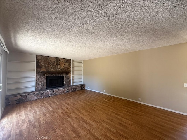 2854 Coronado Ave, San Diego, CA 92154 - unfurnished living room featuring a textured ceiling, wood finished floors, a fireplace, and built in features