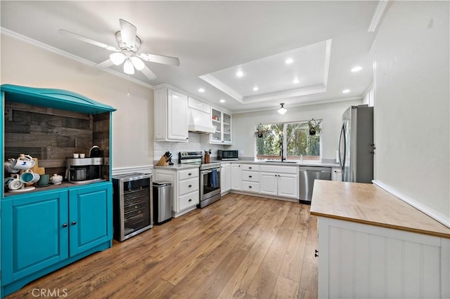 1828 Wintergreen, Escondido, CA 92026 - kitchen featuring stainless steel appliances, beverage cooler, crown molding, premium range hood, and light wood finished floors