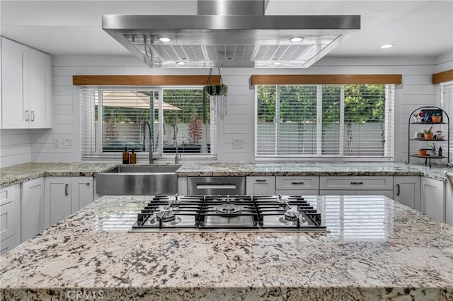 3652 San Joaquin Ave, Los Alamitos, CA 90720 - kitchen featuring exhaust hood, healthy amount of natural light, white cabinets, and light stone counters