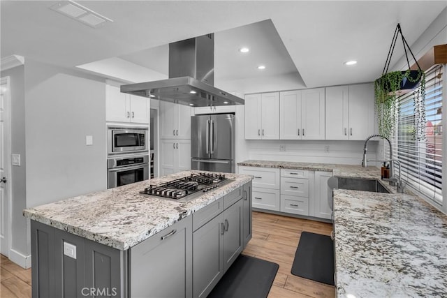 3652 San Joaquin Ave, Los Alamitos, CA 90720 - kitchen with light wood-style flooring, island range hood, recessed lighting, light stone counters, and white cabinetry