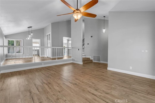 3652 San Joaquin Ave, Los Alamitos, CA 90720 - unfurnished living room featuring a ceiling fan, wood finished floors, stairs, high vaulted ceiling, and a chandelier