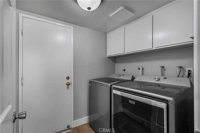 3652 San Joaquin Ave, Los Alamitos, CA 90720 - washroom featuring cabinet space, washer and clothes dryer, and light wood-style flooring