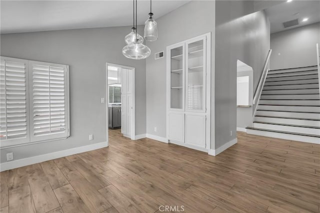 3652 San Joaquin Ave, Los Alamitos, CA 90720 - unfurnished dining area with wood finished floors, stairs, and lofted ceiling