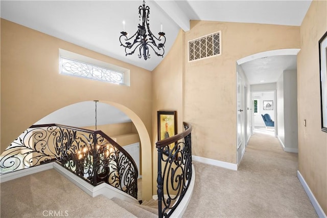 26356 Sorrell Pl, Laguna Hills, CA 92653 - stairway featuring carpet flooring, a chandelier, healthy amount of natural light, beam ceiling, and arched walkways