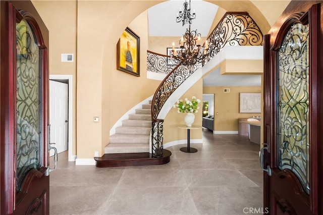 26356 Sorrell Pl, Laguna Hills, CA 92653 - entrance foyer featuring arched walkways, a chandelier, stairs, and a towering ceiling