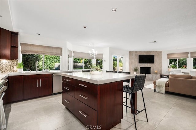 26356 Sorrell Pl, Laguna Hills, CA 92653 - kitchen featuring light countertops, a breakfast bar, a premium fireplace, a kitchen island, and backsplash